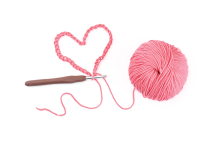 pink ball of yarn with crochet chain heart and crochet hook
